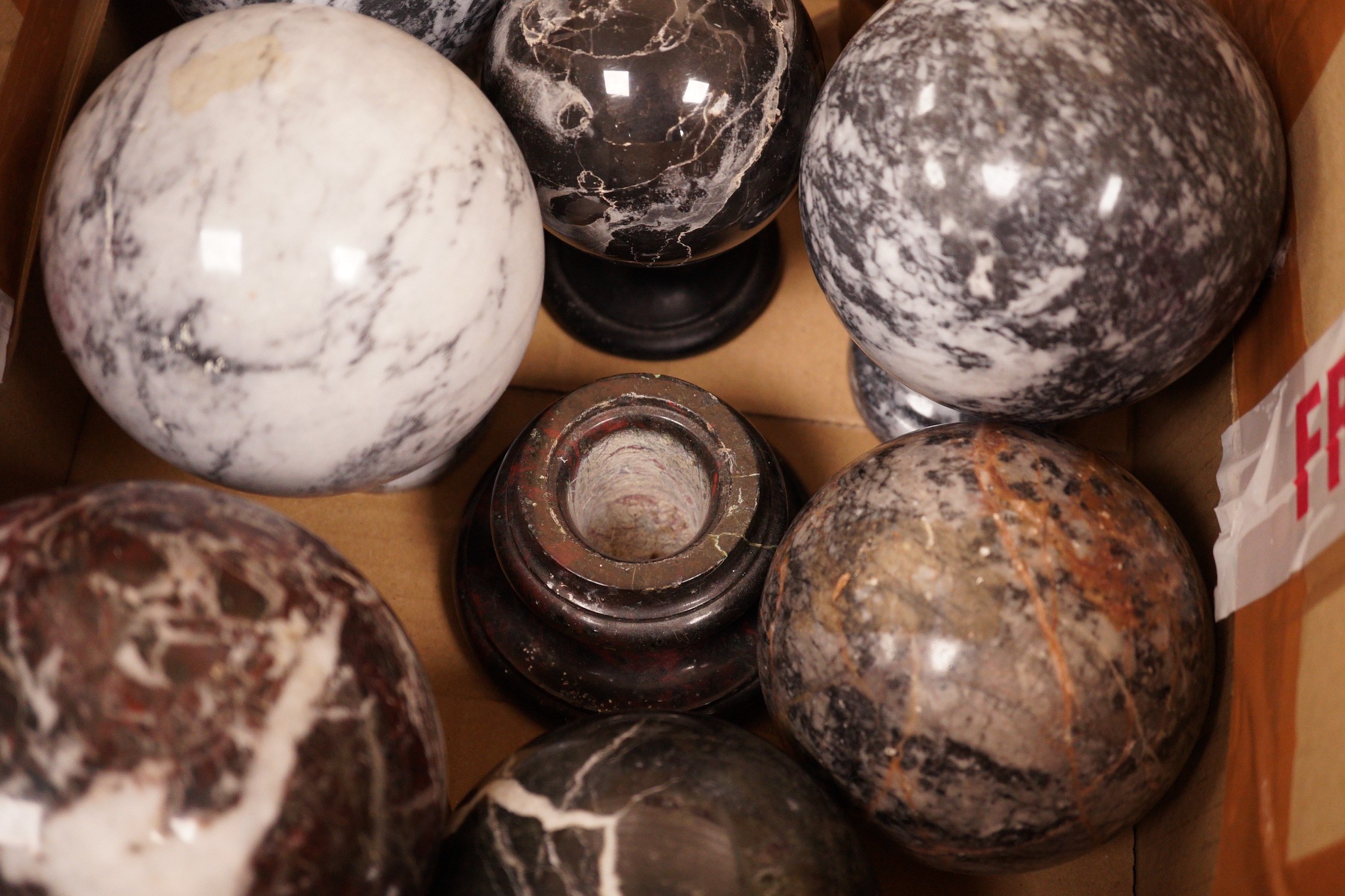 A quantity of carved marble balls on stands